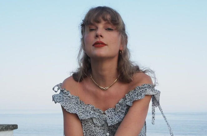 taylor swift in light blue dress against the blue sky and blue sea